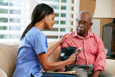 lady nurse checking the blood pressure of the old man