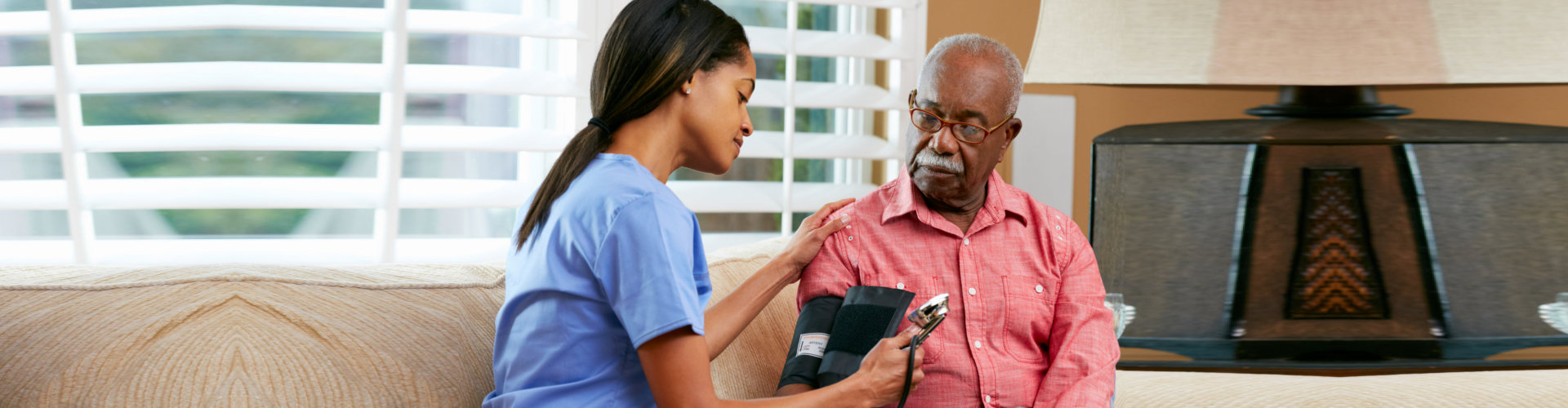 lady nurse checking the blood pressure of the old man